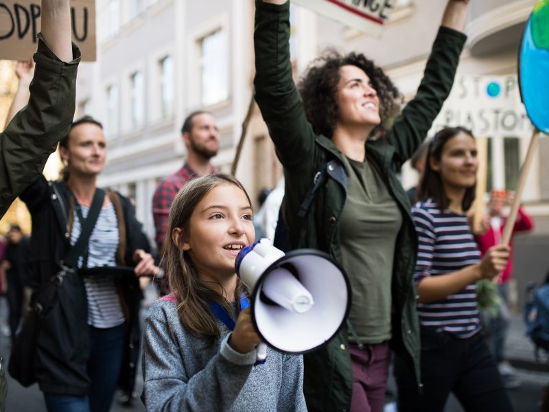 Girl with megaphone infront of a crowd of people