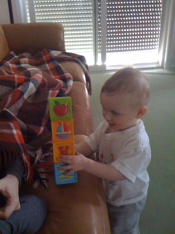 a toddler holding a stack of blocks