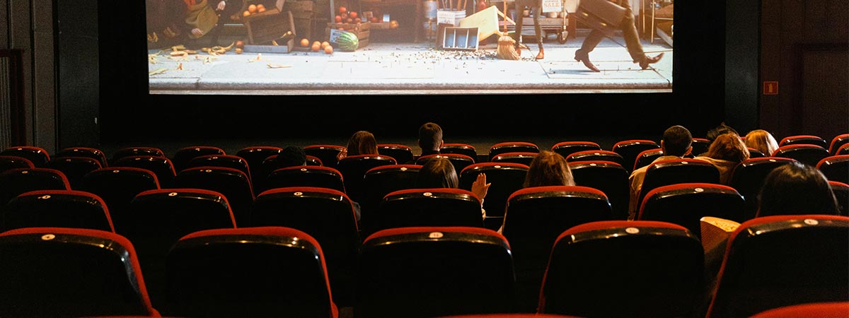 Film Analysis scene of movie goers seated in theater watching a city sidewalk